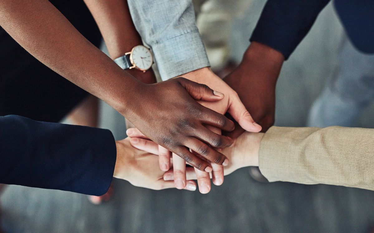 Team all clasping hands together for teamwork