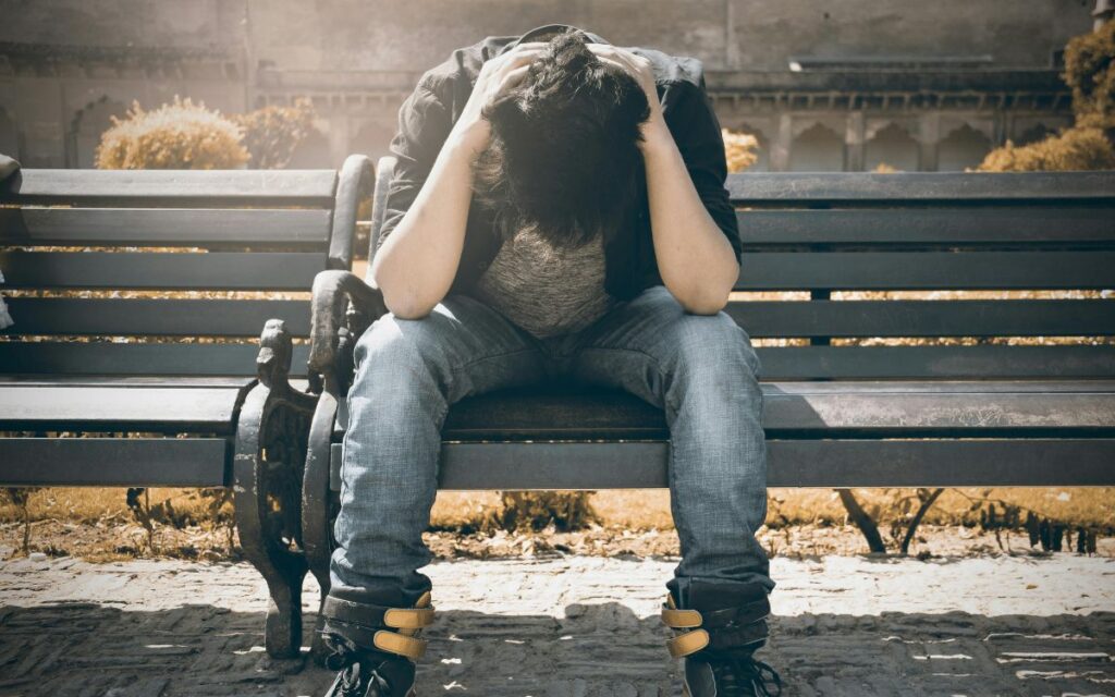 young adult holding their heading dealing with depression