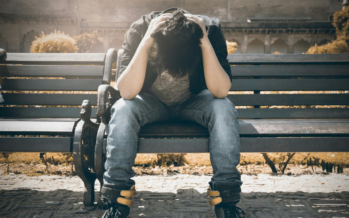 young adult holding their heading dealing with depression