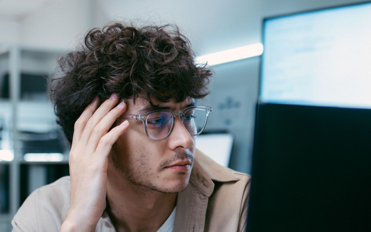 young adult male looking at computer screens