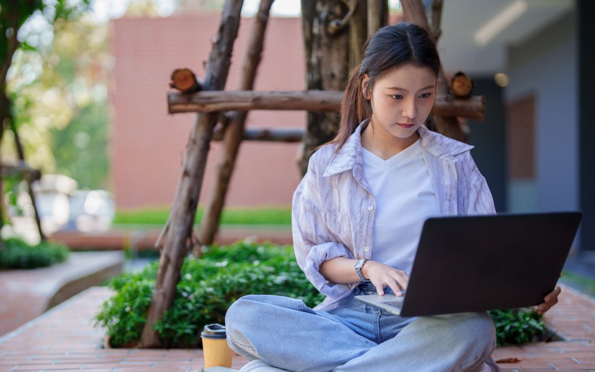 A women sitting outside on her laptop