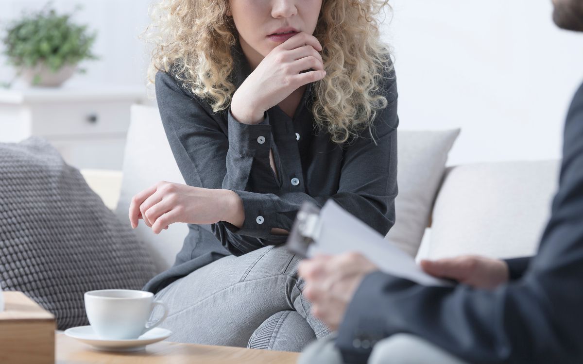 A young blonde woman talking to a therapist